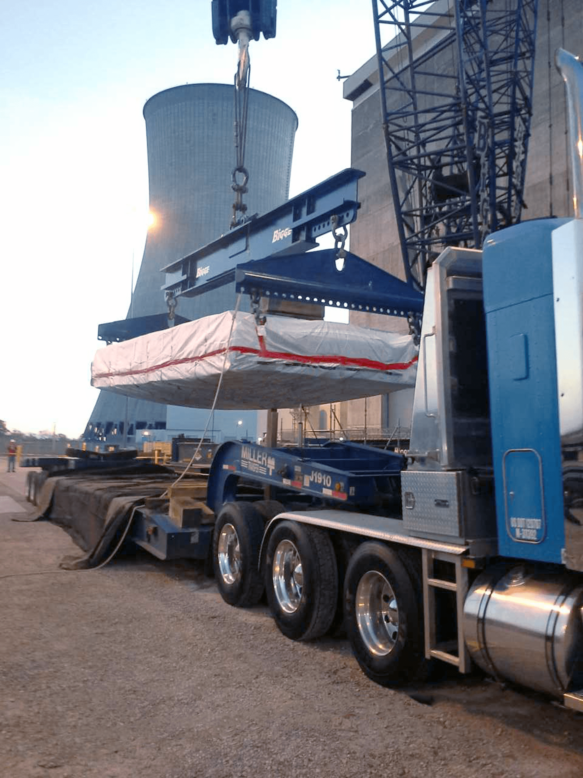 [[I] NucPac- Square NucPac Lowered by Frame Onto Flatbed